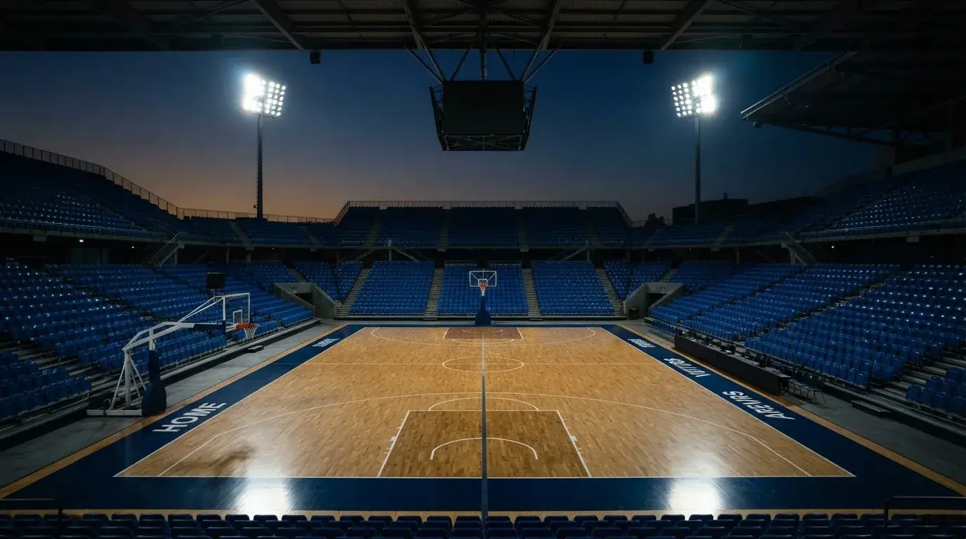 An empty football stadium with floodlight masts at dusk