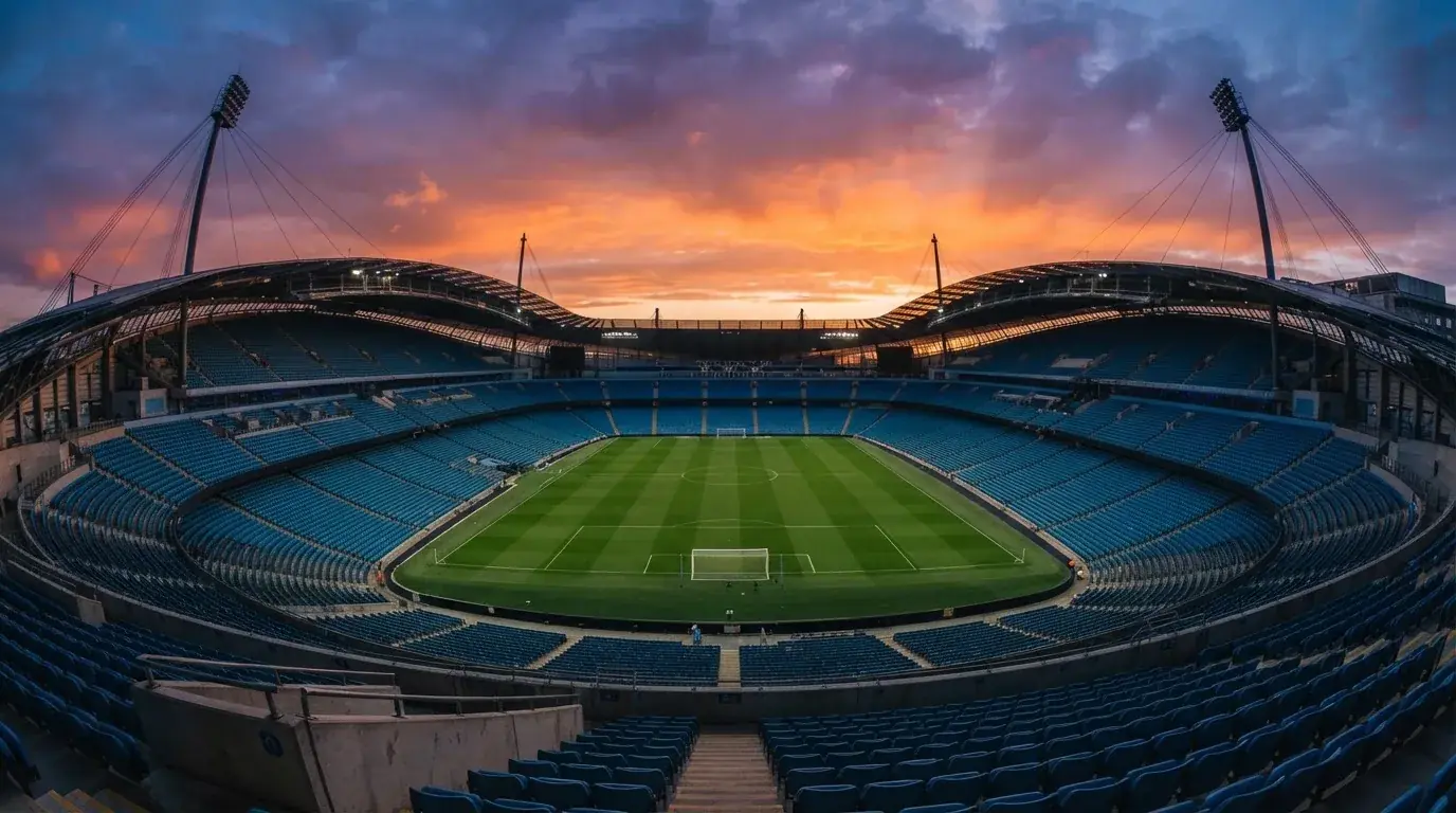An empty football stadium with floodlight masts at dusk